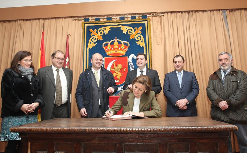 Cospedal firma en el libro de visitas del Ayuntamiento de Huete acompañada del alcalde y concejales